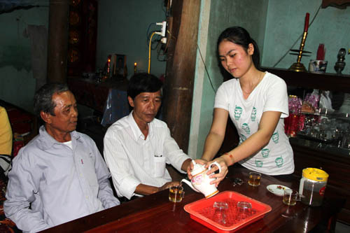 Nguyễn Thị Bích Phượng – cô gái đỗ thủ khoa khối C - rót nước mời ông nội và bà con chòm xóm trong nhà chật hẹp ở Thị trấn Trà Xuân, huyện Trà Bồng (Quảng Ngãi).